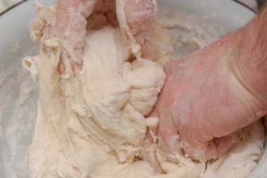 Evde beyaz metal bir kasede hamur pişirmek.