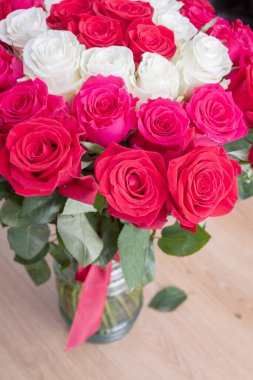 Vazoda çok renkli kırmızı, pembe ve beyaz güller.