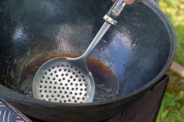 Yazın dışarıdaki ızgarada kazanda pilav pişirmek.