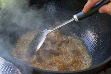 Yazın dışarıdaki ızgarada kazanda pilav pişirmek.