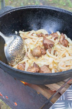 Yazın dışarıdaki ızgarada kazanda pilav pişirmek.