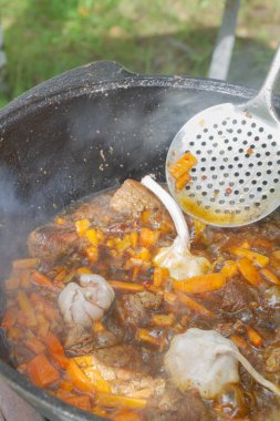 Yazın dışarıdaki ızgarada kazanda pilav pişirmek.