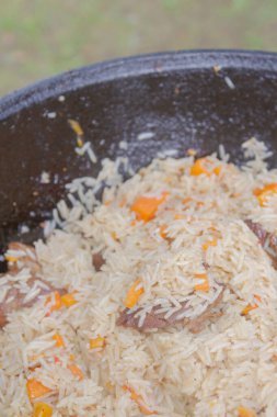 Yazın dışarıdaki ızgarada kazanda pilav pişirmek.