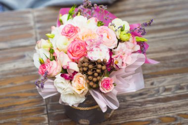 bir kutu ahşap arka plan üzerinde dekore edilmiş çok renkli gül buketi.