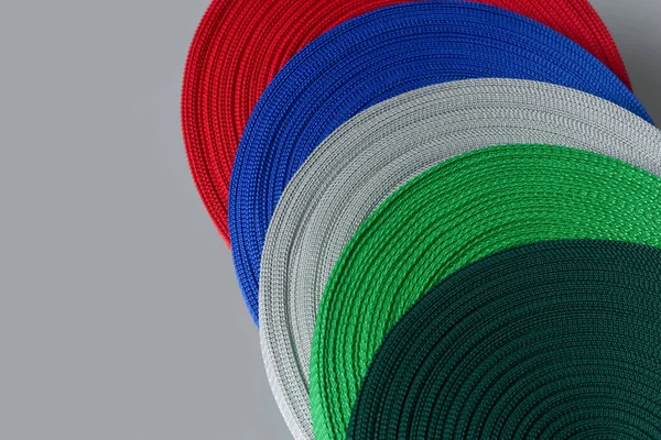 Rollos de cinta textil sobre fondo gris. producción de cinta de color . —  Fotos de Stock
