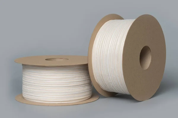 Role textilní pásky na šedém pozadí. výroba barevné pásky. — Stock fotografie