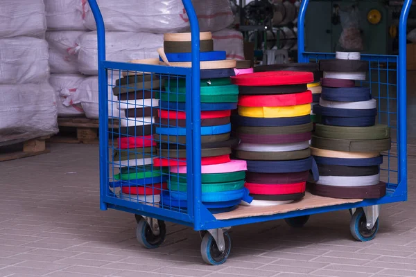 Rollos de cinta textil sobre fondo gris. producción de cinta de color . Imagen De Stock