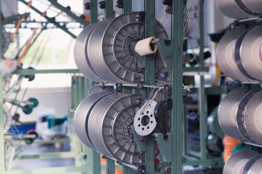 Bir giysi fabrikasında mekanik ekipman. İplik üretim araçları.