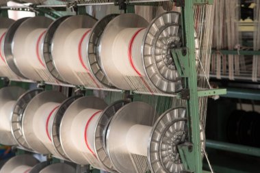 Bir giysi fabrikasında mekanik ekipman. İplik üretim araçları.