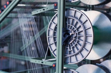 Bir giysi fabrikasında mekanik ekipman. İplik üretim araçları.