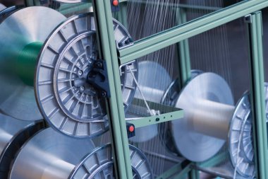 Bir giysi fabrikasında mekanik ekipman. İplik üretim araçları.