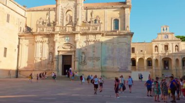 Lecce Katedrali yaz güneşi altında Duomo Meydanı 'nda turistlerle dolu.