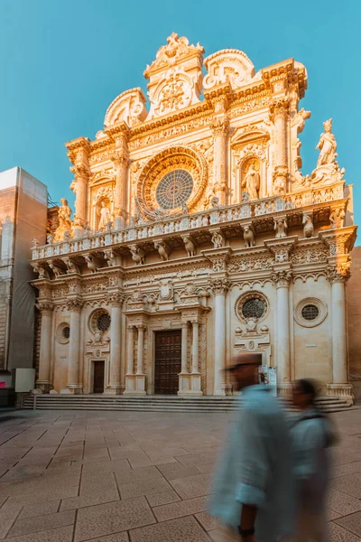 Lecce, Puglia - 11 Ağustos 2025: Lecce 'de Basilica di Santa Croce ile sokak sahnesi gün batımında aydınlandı, barok güzelliği ve Akdeniz cazibesini gösterdi.