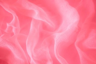 Kırmızı ipek kumaş perdeler, zarif dalgalar, arka plan, tekstil tasarımı. Kırmızı renkli saten kumaşın yakın plan çekimi pürüzsüz ve parlak dokusunu gözler önüne seriyor.