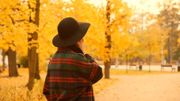 La mujer está hablando por teléfono en el parque de otoño. —  Fotos de Stock