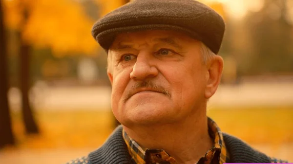 Öreg ember portréja az őszi parkban — Stock Fotó