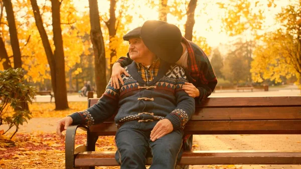 Genç kadın ve yaşlı babası sonbahar parkta toplantı