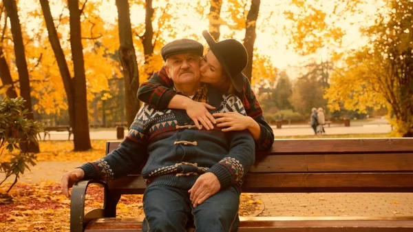 Mujer joven y su viejo padre en la reunión en el parque de otoño —  Fotos de Stock