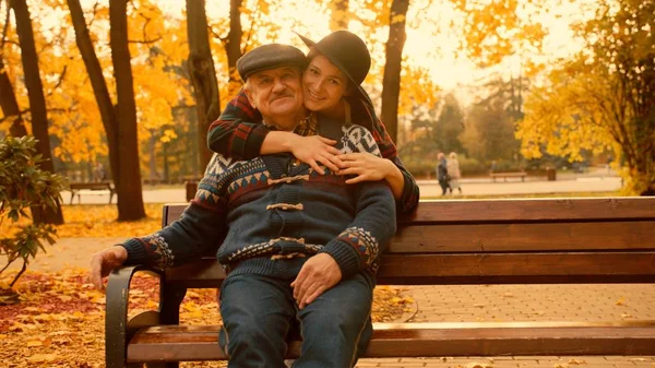 Genç kadın ve yaşlı babası sonbahar parkta toplantı