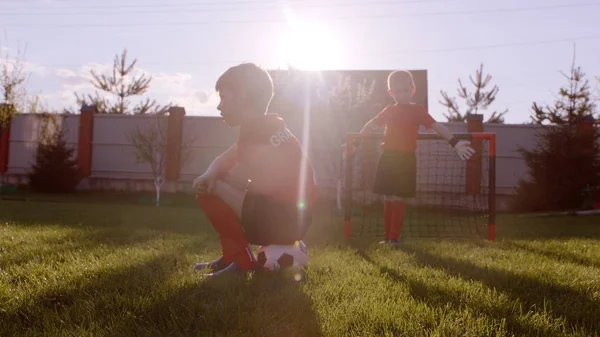 Little boys are playing football on the lawn at the backyard — Stock Photo, Image