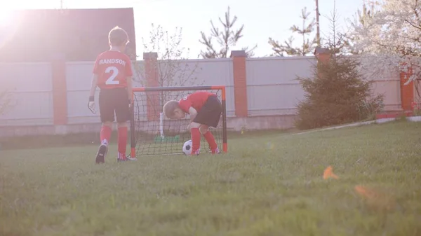 Chłopcy są gry w piłkę nożną na trawniku w ogrodzie — Zdjęcie stockowe