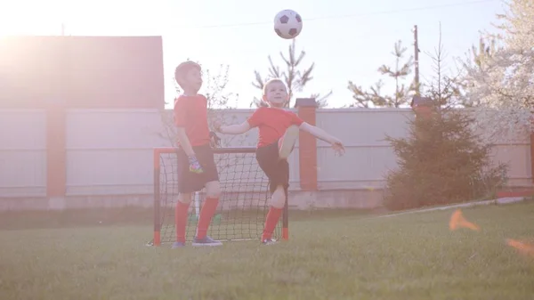Chłopcy są gry w piłkę nożną na trawniku w ogrodzie — Zdjęcie stockowe