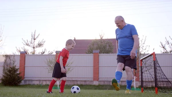 Granfather arka bahçe'nın bahçesinde futbol torunu ile oynuyor