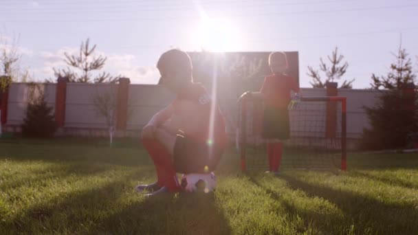 男の子は裏庭の芝生でサッカーした後は動揺しています。 — ストック動画