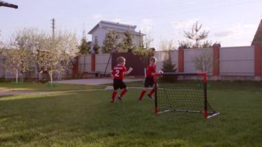 Küçük çocuklar arka bahçe'nın bahçesinde futbol oynayan