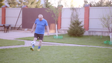 Mutlu yaşlı adam ile birlikte futbol oynamaya torunu