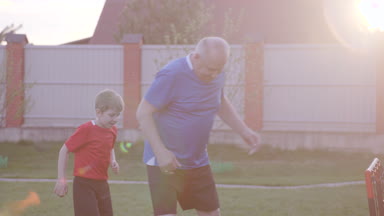 Mutlu yaşlı adam ile birlikte futbol oynamaya torunu