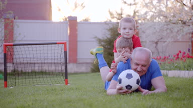 Futbol oynarken onun torunları ile mutlu yaşlı adam
