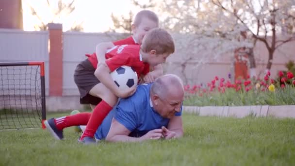 Feliz anciano con sus nietos jugando al fútbol — Vídeos de Stock