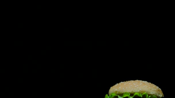 Close up of delicious burger with double cheese and french fries. Black background — Stock Video