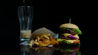 Patates kızartması, hamburger ve ticari kullanım için siyah arka plan üzerine coca-cola ile cam