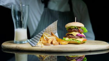 Lezzetli hamburger, patates kızartması, hizmet veren, bira cam ahşap tepsi içine dökme Şef