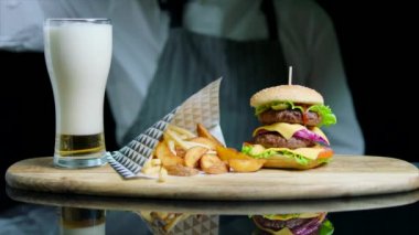 Lezzetli hamburger, patates kızartması, hizmet veren, bira cam ahşap tepsi içine dökme Şef
