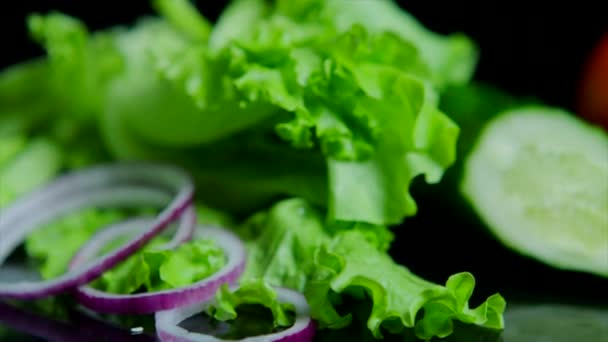 Nahaufnahme von frischem Gemüse und leckerem Burger mit Käse und Rinderschnitzeln auf schwarzem Hintergrund — Stockvideo