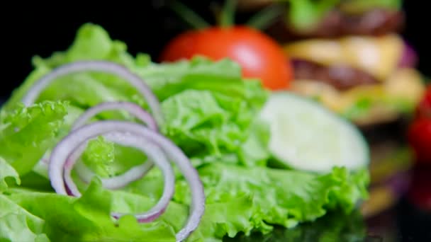 Close up de verduras frescas e delicioso hambúrguer. Fundo preto para uso comercial — Vídeo de Stock