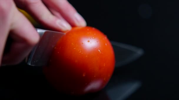 Zbliżenie cięcia świeżych dojrzałych pomidorów z nożem. Powierzchni lustra czarny — Wideo stockowe