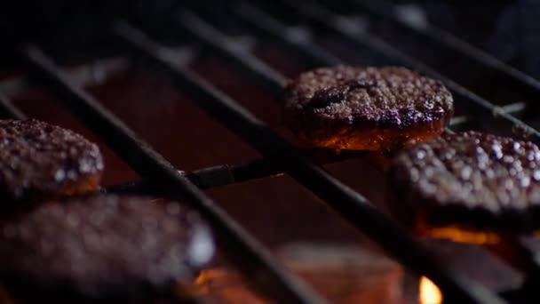 Nahaufnahme von Burger-Schnitzeln auf Grill mit Feuerflammen, Zeitlupe — Stockvideo