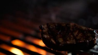 Biftek yakın yangın alevler ile ızgara, Şef onları ağır çekim bitti, döner