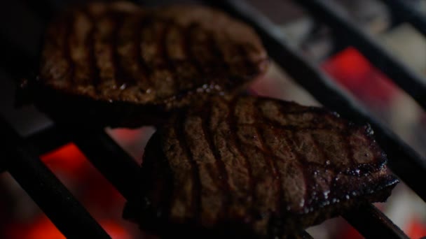Close up de bifes na grelha com chamas de fogo, chef vira-los, câmera lenta — Vídeo de Stock