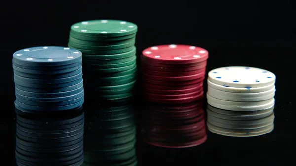 Poker chips on the black mirror surface — Stock Photo, Image