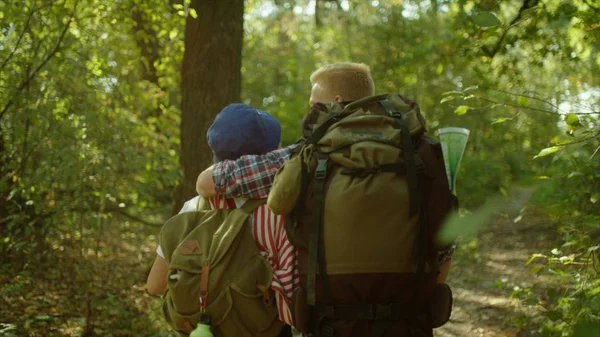 Pareja joven disfrutando del bosque de verano durante el senderismo con mochilas en el parque nacional — Foto de Stock