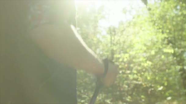 Група мандрівників з рюкзаками і паличками, що ходять у лісі — стокове відео