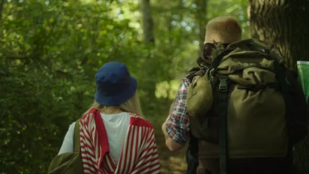 Young couple hugging during hiking in the forest with backpacks — Stock Video