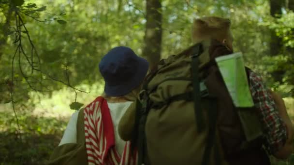 Νεαρό ζευγάρι αγκαλιάζει κατά τη διάρκεια πεζοπορίας μέσα στο δάσος με Σακίδια — Αρχείο Βίντεο