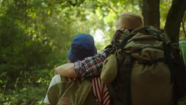 Jeune couple embrasser pendant la randonnée dans la forêt avec des sacs à dos — Video