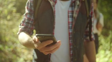 Ormanda yürüyüş üzerinde cep telefonu navigasyon kullanarak gezgin